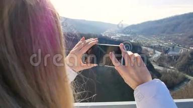 女人在峡谷上空的天空桥上拍摄自然风光